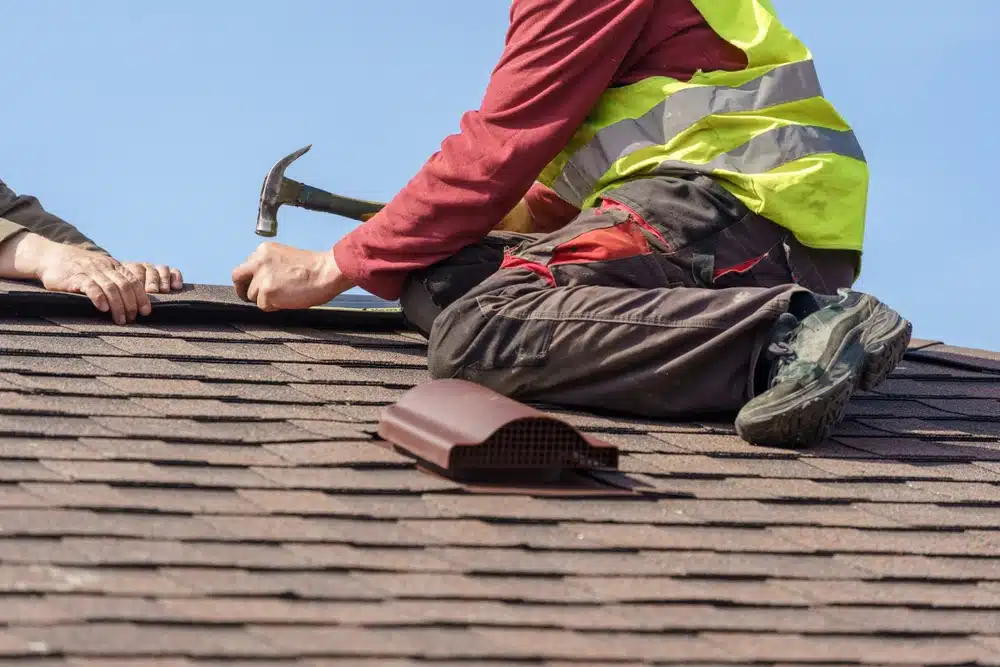 Roofer installing asphalt shingles